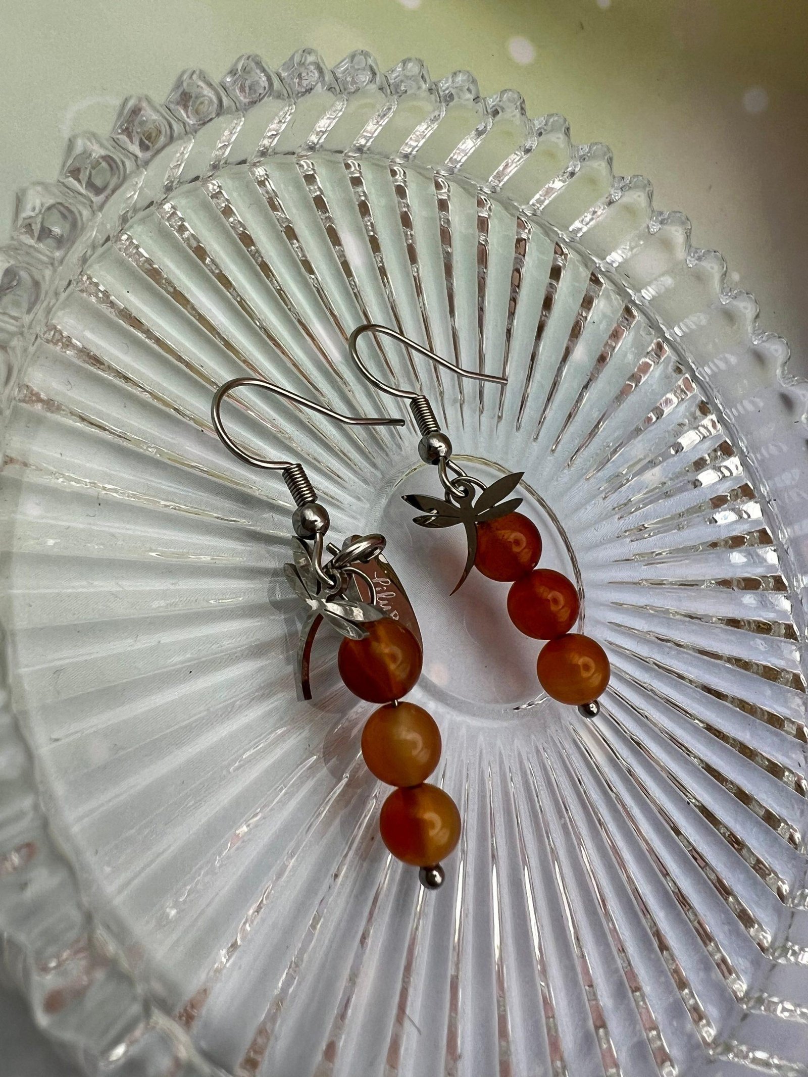 Détail des boucles d’oreilles en cornaline avec trois perles orangées et pampille libellule argentée – bijou LiluBelle