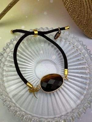 Détail du bracelet cordon en oeil de tigre avec pampille libellule dorée