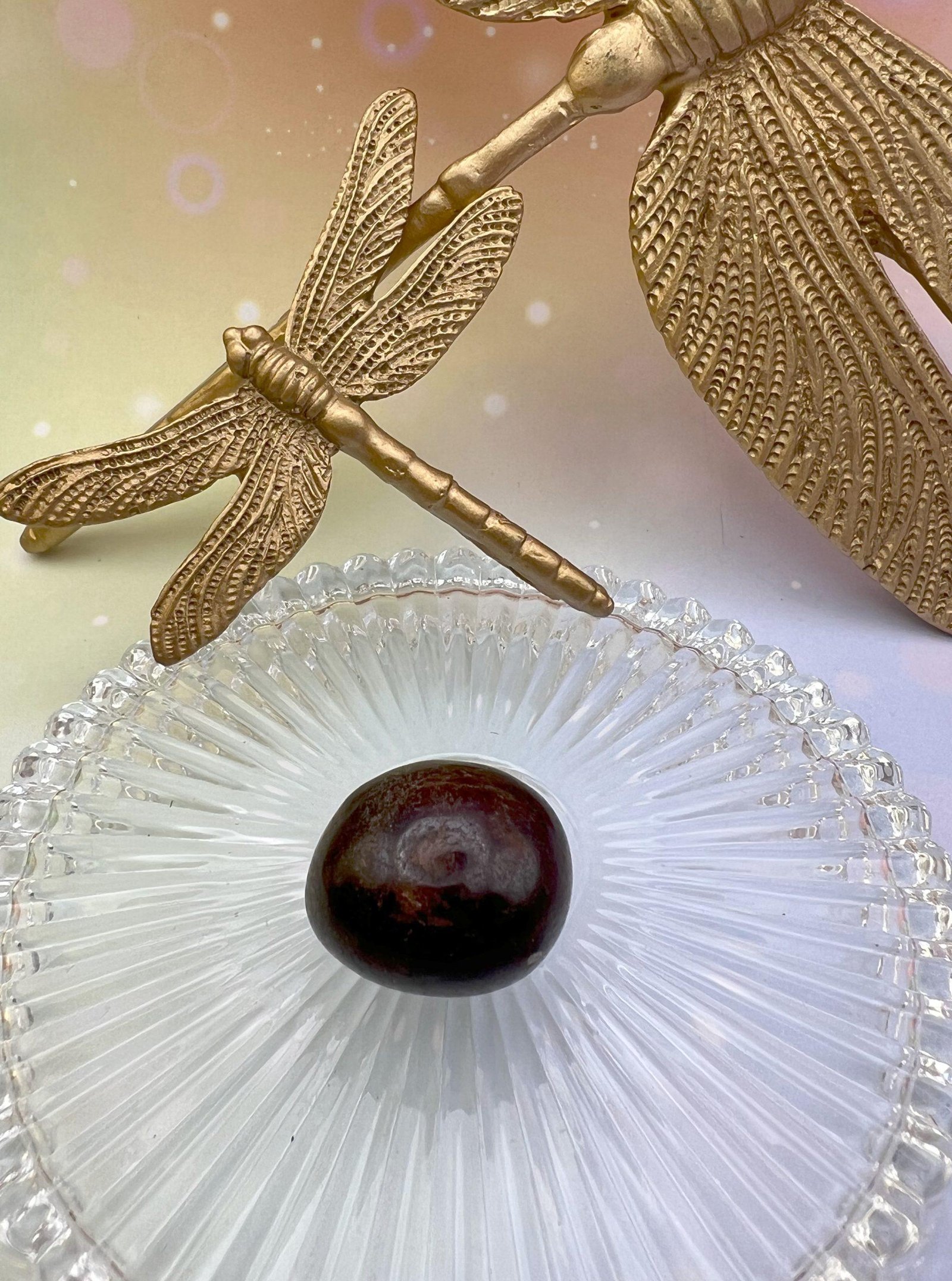 Pierre roulée en grenat rouge entourée de libellules dorées – symbole d’énergie, de passion et d’enracinement