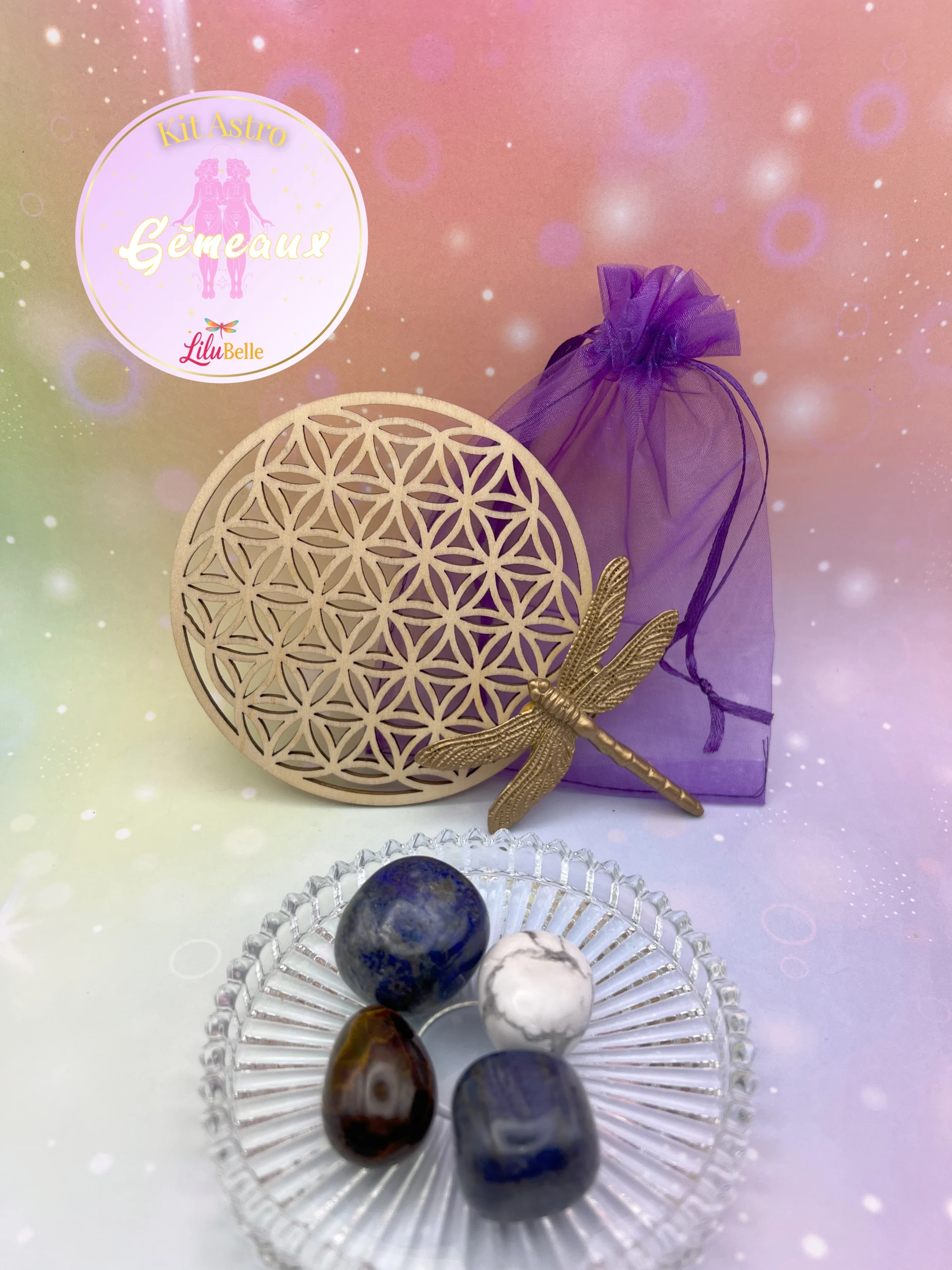 Kit Astro Gémeaux avec quatre pierres roulées, une fleur de vie en bois et un pochon violet, présenté sur fond pastel.