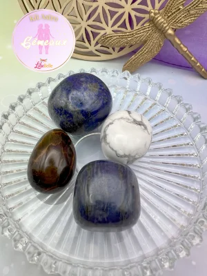 Gros plan sur les quatre pierres du Kit Astro Gémeaux : Lapis-lazuli, Œil de tigre, Howlite et Sodalite posées dans une coupelle transparente.
