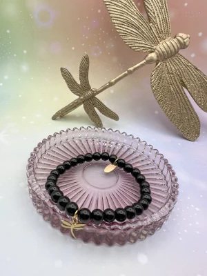Bracelet en obsidienne noire entouré de libellules dorées – symbole d’ancrage, de protection et de force intérieure